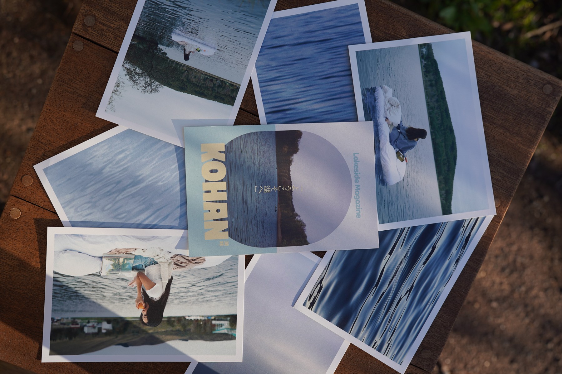 Lake photo postcards arranged on a wooden table